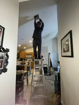 Mighty Ducts technician cleaning a ceiling vent in a commercial office