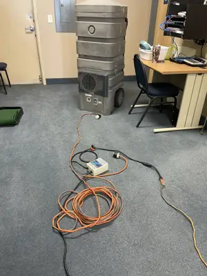Portable duct-cleaning vacuum unit set up in an office