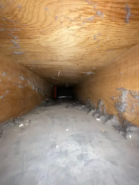 Dust and debris built up inside a residential air duct trunk line