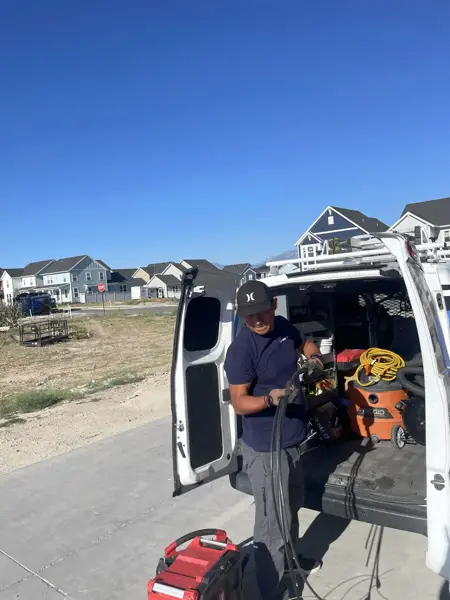 Mighty Ducts technician at the service van with equipment at a residential job